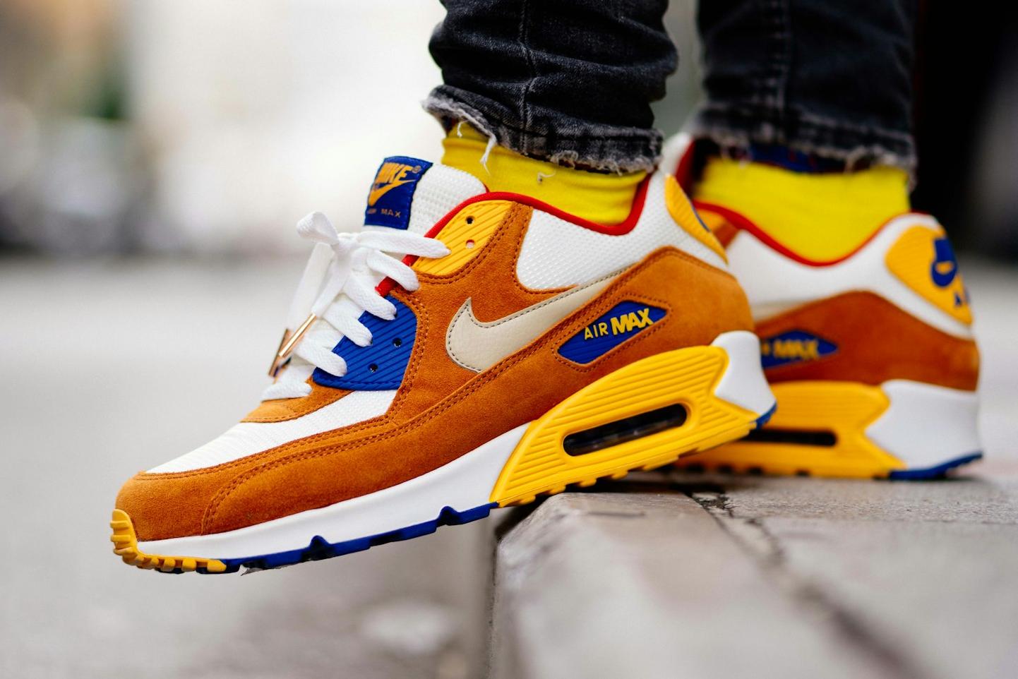 close-up photography of person wears brown-and-white Nike Air Max